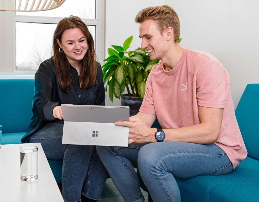 Man en vrouw achter laptop op kantoor